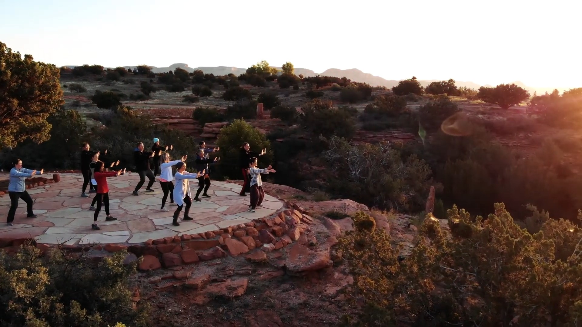 Retreat participants practicing mindful movement in a red-rock landscape